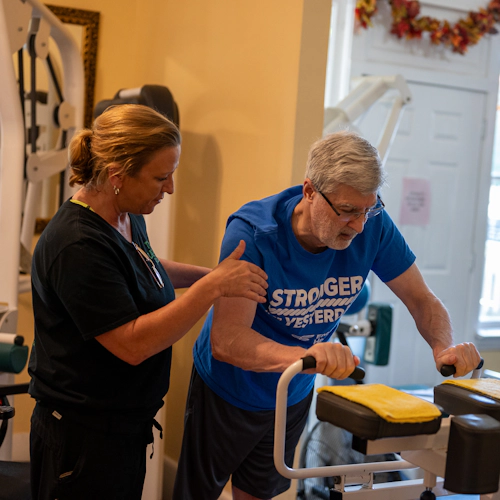 A trainer working with a man doing vertical push-ups.